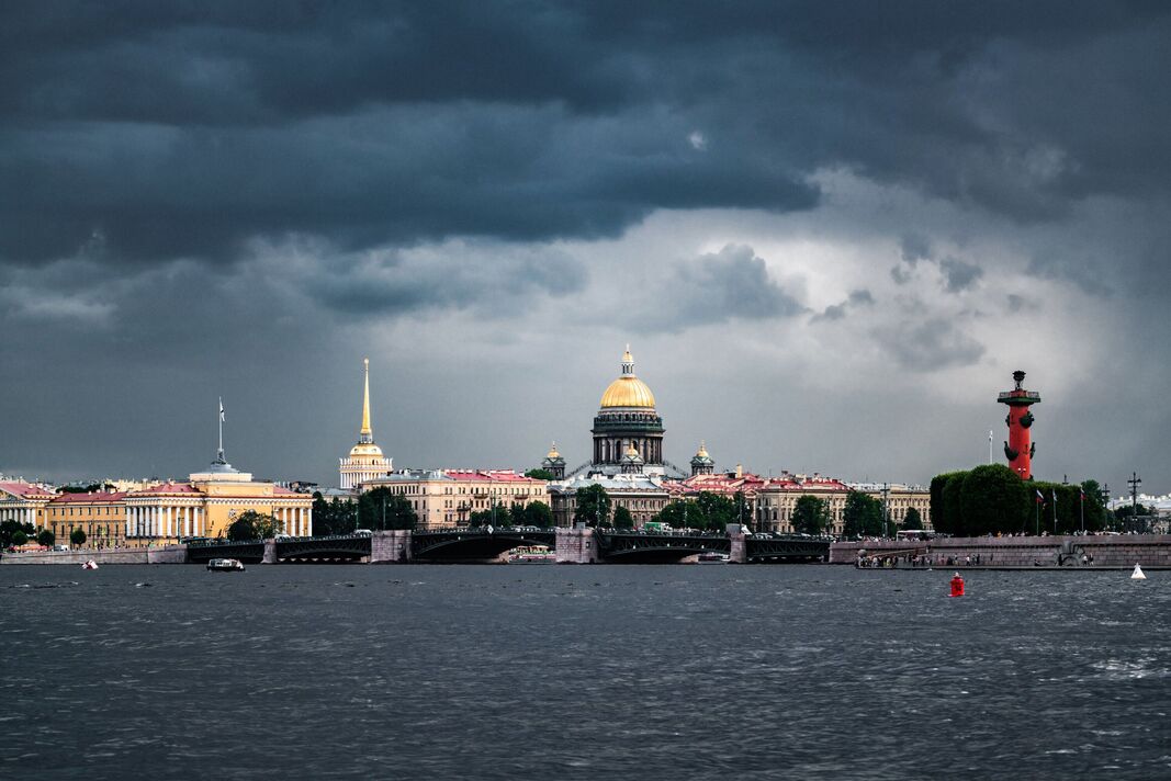 La cathédrale et la broche de Saint Isaac de l'île de Vasilievsky vue de la rivière Neva. Des nuages pluvieux dramatiques en arrière-plan. Saint-Pétersbourg