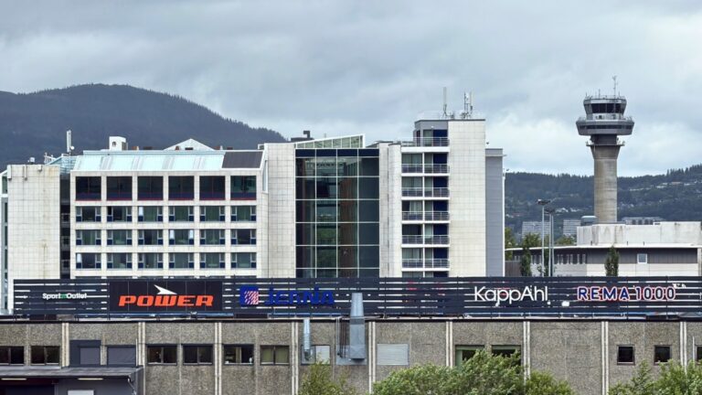 Vue du Scandic Hell Hotel et du centre commercial Hell avec la tour de contrôle de l'aéroport de Trondheim en arrière-plan.
