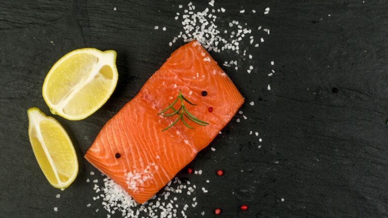 Un filet de saumon norvégien au citron et au sel sur un tableau noir.