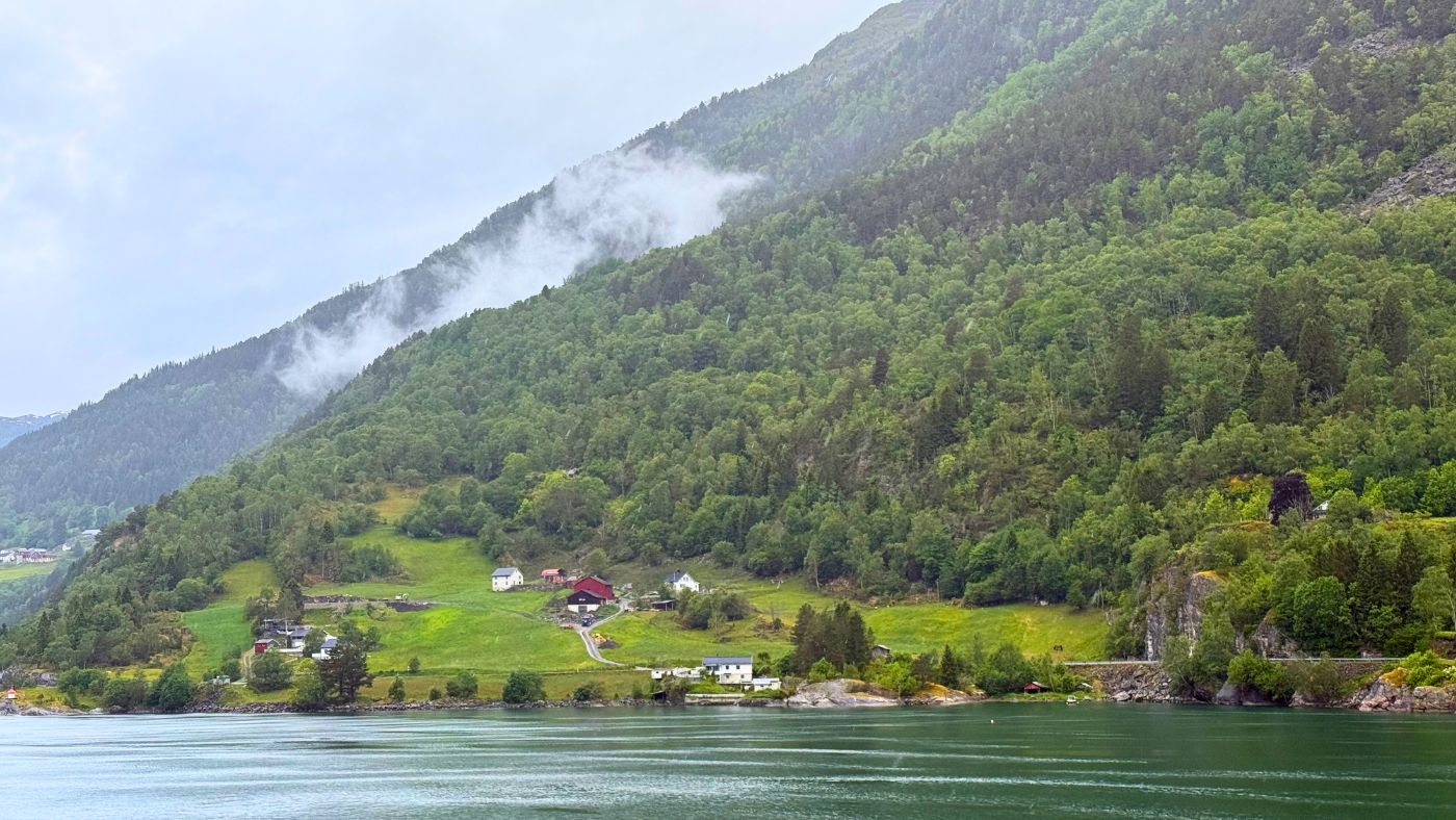 Cabins on the shoreline in a Norwegian fjord landscape. Photo: David Nikel.